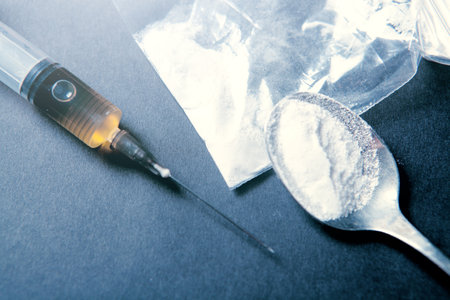 syringe and powder in a package spoon on a blue background