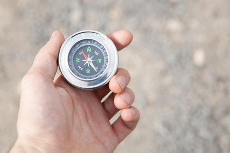 holds a compass on the background of asphalt during the dayの写真素材