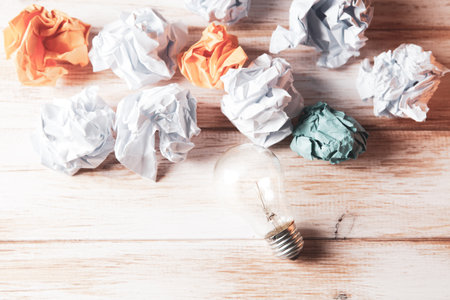 wads of paper and a light bulb on the tableの写真素材