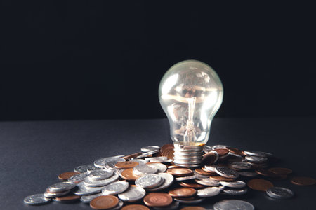 glowing lamp and coins on a dark backgroundの写真素材