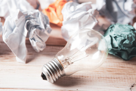 wads of paper and a light bulb on the tableの写真素材