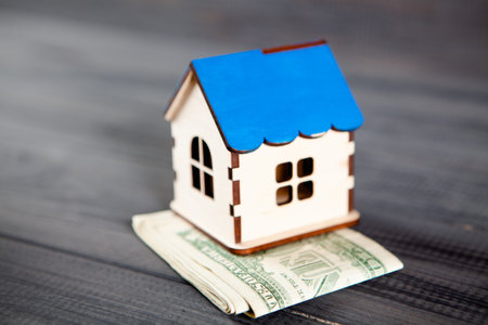 house on dollar bills on a gray wooden tableの写真素材