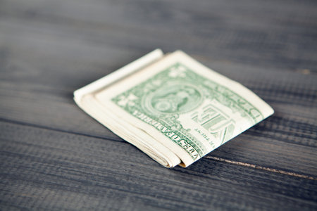 dollar bills on a gray wooden table