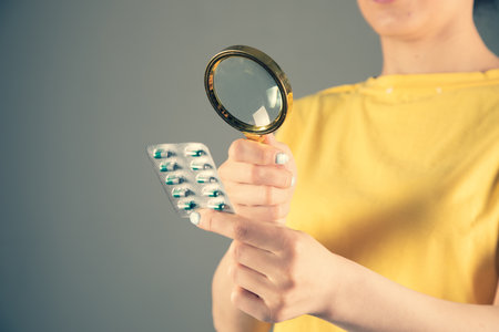 Magnifier looks at the pills. Study and search for drugsの写真素材