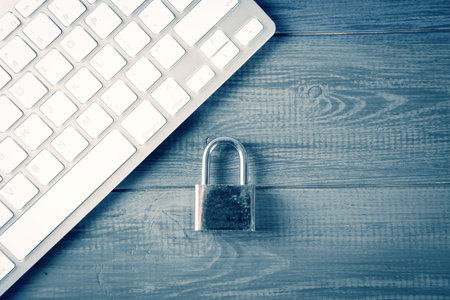 Computer security concept. Unlocked padlock on laptop keyboard. Safe symbol. Selective focus on gray...