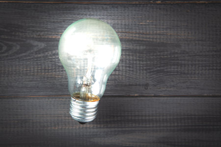 light bulb on gray wooden backgroundの写真素材