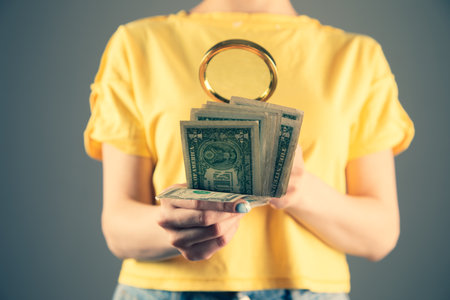 a girl in a yellow dress looks at the bills with a magnifying glass