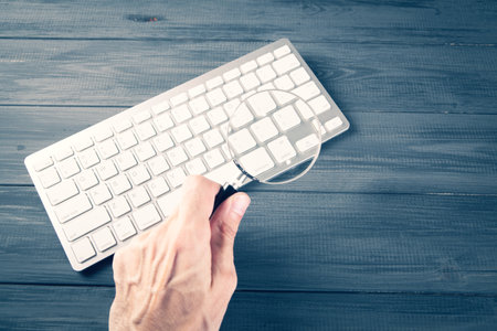 keyboard and magnifier. search concept on gray wooden tableの写真素材