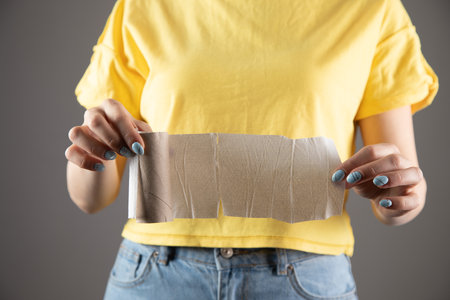 a girl in a yellow dress holds toilet paperの写真素材