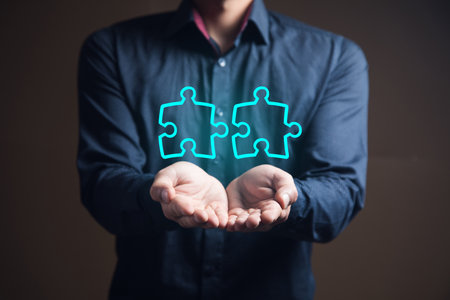 businessman holding pieces of drawn puzzlesの写真素材