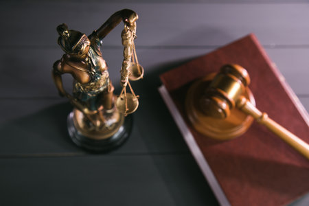 statue of justice, book and gavel on wooden table