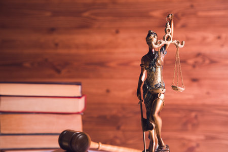 statue of justice, book and gavel on wooden table