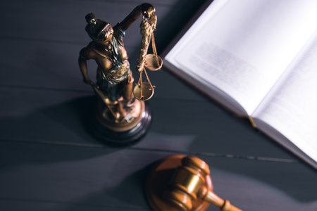 statue of justice, book and gavel on wooden table