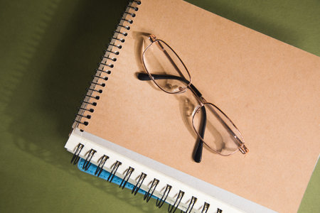 optical glasses on notebooks on a green table