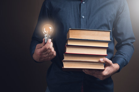 man holding books and a light bulb. concept ideas from books