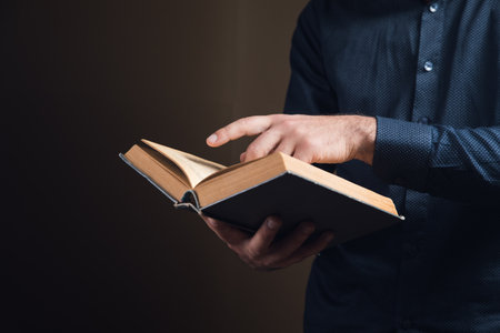 young man reading a book on brown backgroundの写真素材