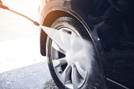 a man washes his car with waterの写真素材
