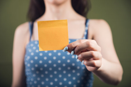 young girl holding a piece of paperの写真素材