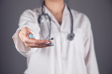 doctor holding empty palm on gray backgroundの写真素材