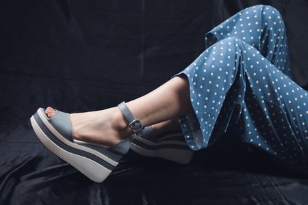 young woman sitting on a black floor posingの写真素材