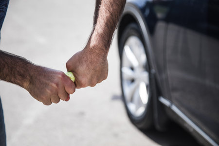 a man squeezes out a rag near the carの写真素材