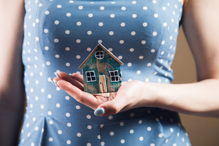 Young woman holding house in handsの写真素材
