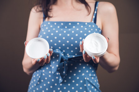 young woman holding a container of creamの写真素材