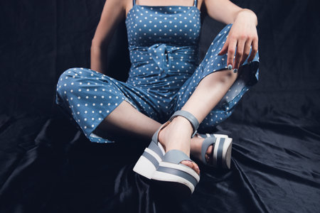 young woman sitting on a black floor posing