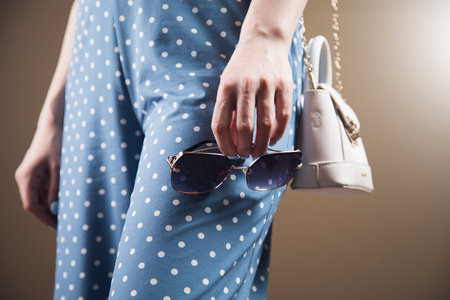 young woman posing with bag and glassesの写真素材