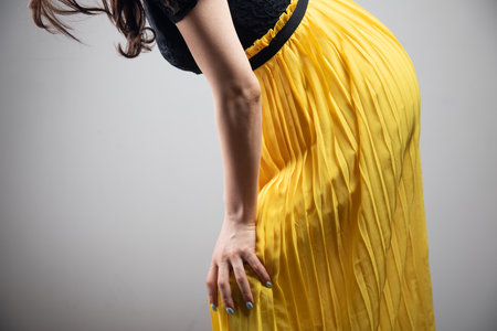 a young woman in a dress has a knee painの写真素材
