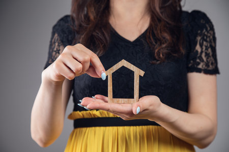 woman holding a house in her handsの写真素材