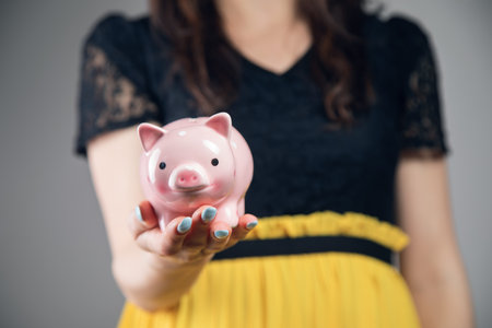 young woman holding a piggy bankの写真素材
