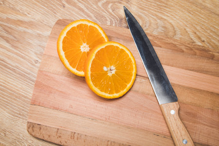 a knife and an orange on a wooden tableの写真素材