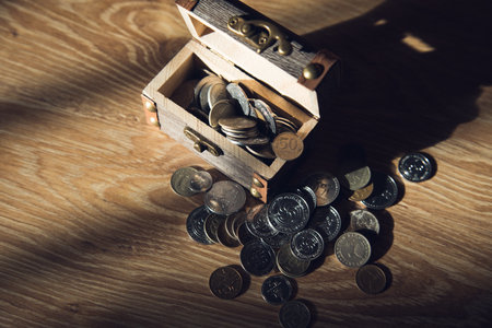 on a wooden table a small chest with coinsの写真素材