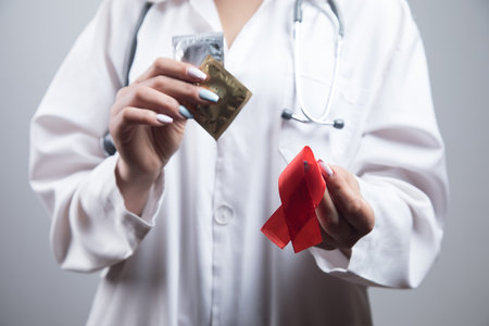 doctor holds condoms and red tape. concept protection from aids
