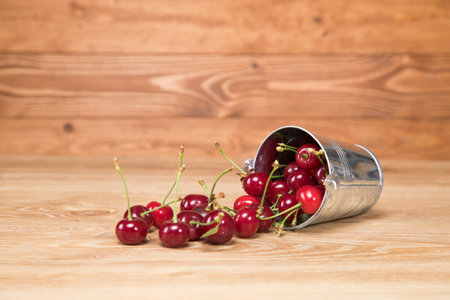 on the table red cherries in a small bucketの写真素材
