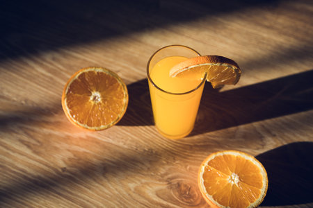 orange juice sliced oranges on a wooden tableの写真素材