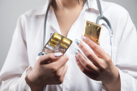doctor holds a condom and pills. protectionの写真素材