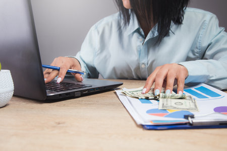 woman sitting in front of her work table studying papers and dataの写真素材