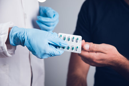 the doctor gives pills to the manの写真素材