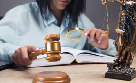 the judge hits with a hammer sitting in front of the statue of justice