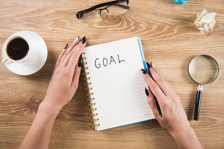 girl writes goals in a notebook. writing goals