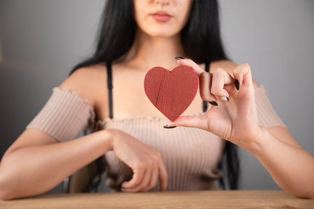 woman holding a wooden heartの写真素材