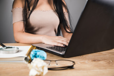 woman sitting in front of work table working laptop