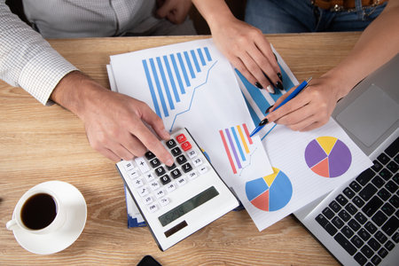 businessmen are discussing business while sitting in front of charts