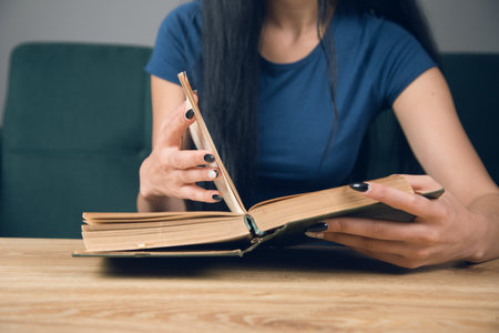 A girl reading a book in front of a table