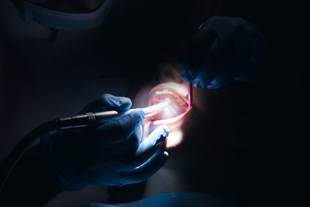 Dentist performs surgery in a dark roomの写真素材