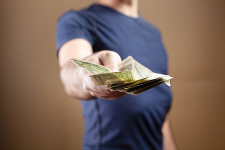 a man gives money on a brown background