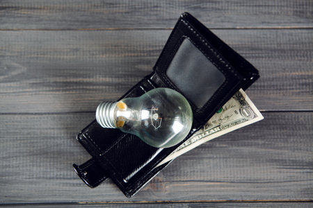 light bulb on wallet on wooden tableの写真素材