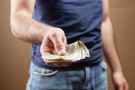 man gives money on brown background
